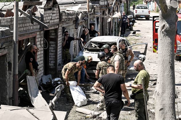 Law enforcement officers, forensic experts and military personnel record damage at a garage cooperative caused by a Russian guided aerial bomb strike in the Voznesenivskyi district of Zaporizhzhia, Ukraine, July 20, 2026. The attack destroyed or damaged privately owned garages, while the blast wave and debris wrecked civilian cars. A woman was killed at the site of the strike, and five others were injured. (Photo by Dmytro Smolienko Ukrinform) Russian strike garage co-op in central Zaporizhzhia with guided bomb  Copyright: xDmytroxSmolienkox