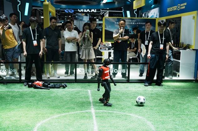 SHANGHAI, CHINA - JULY 20: Spectators watch Booster Robotics Booster T2 robots competing in a 2-on-2 football match during the 2026 World Artificial Intelligence Conference on July 20, 2026 in Shanghai, China. The 2026 World AI Conference and High-Level Meeting on Global AI Governance scheduled from July 17 to July 20 showcases exhibitions of smart devices, AI plus culture and entertainment experiences, and a wide range of cutting-edge AI products, among which a range of humanoid robots and AI-powered dexterous hands as one of the highlights.  Copyright: xVCGx 111655541751