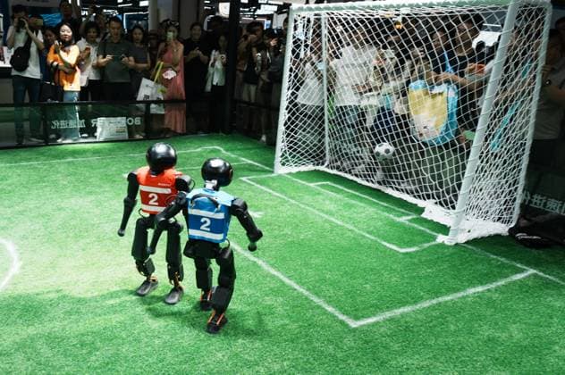 SHANGHAI, CHINA - JULY 20: Spectators watch Booster Robotics Booster T2 robots competing in a 2-on-2 football match during the 2026 World Artificial Intelligence Conference on July 20, 2026 in Shanghai, China. The 2026 World AI Conference and High-Level Meeting on Global AI Governance scheduled from July 17 to July 20 showcases exhibitions of smart devices, AI plus culture and entertainment experiences, and a wide range of cutting-edge AI products, among which a range of humanoid robots and AI-powered dexterous hands as one of the highlights.  Copyright: xVCGx 111655541746