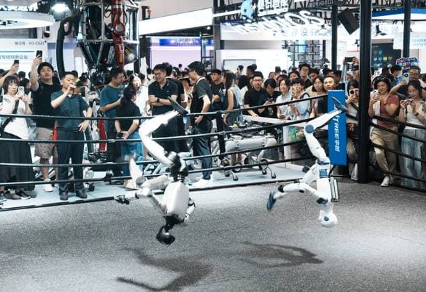 SHANGHAI, CHINA - JULY 20: Visitors watch G1 and R1 humanoid robots from Unitree Robotics perform synchronized backflips during the 2026 World AI Conference on July 20, 2026 in Shanghai, China. The conference showcases latest advancements in artificial intelligence and robotics technologies.  Copyright: xVCGx 111655410351