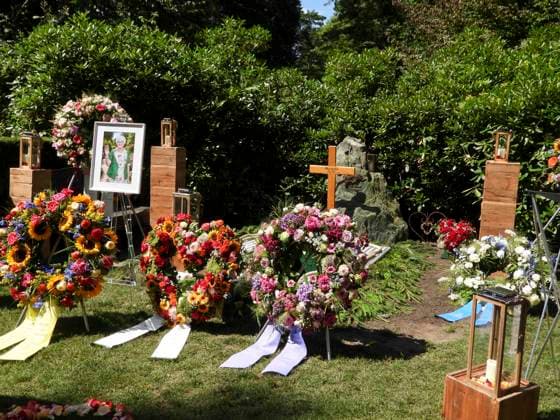 CNTV OHLSDORF- Blumen und Trauer Kraenze liegen vor einem Holzkreuz und dem Bild der versorbenen auf der Grabstelle Grab von Ilka Seeler die Ehefrau vom verstorbenen Fußballer Uwe Seeler wurde heute neben ihrem Mann beerdigt 21.07.2026 Hamburg - Ohlsdorf Hamburg Deutschland *** CNTV OHLSDORF Flowers and funeral wreaths lie in front of a wooden cross and a portrait of the deceased at the gravesite. The grave of Ilka Seeler, wife of the late soccer player Uwe Seeler, was laid to rest today next to her husband. July 21, 2026, Hamburg-Ohlsdorf, Hamburg Germany