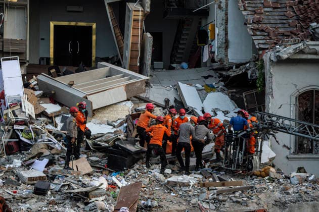 Police Investigate Fatal House Explosion - Medan Members of the Joint SAR Team carry a body bag containing the third victim found under the rubble of a four-story house that exploded in Medan, North Sumatra, on July 21, 2026. A police officer oversees the evacuation on the second floor. The SAR team, along with police and forensic units, used heavy equipment to clear debris before discovering the victim. Medan Police Chief, Sr. Comr. Jean Calvijn Simanjuntak, confirmed that the initial investigation is complete, with further inquiries ongoing to check for other substances at the scene. Photo by Aditya Sutanta ABACAPRESS.COM Medan Sumatra Indonesia  Copyright: xAdityaxSutanta ABACAx