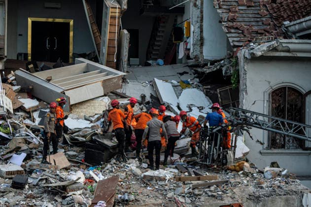 Police Investigate Fatal House Explosion - Medan Members of the Joint SAR Team carry a body bag containing the third victim found under the rubble of a four-story house that exploded in Medan, North Sumatra, on July 21, 2026. A police officer oversees the evacuation on the second floor. The SAR team, along with police and forensic units, used heavy equipment to clear debris before discovering the victim. Medan Police Chief, Sr. Comr. Jean Calvijn Simanjuntak, confirmed that the initial investigation is complete, with further inquiries ongoing to check for other substances at the scene. Photo by Aditya Sutanta ABACAPRESS.COM Medan Sumatra Indonesia  Copyright: xAdityaxSutanta ABACAx