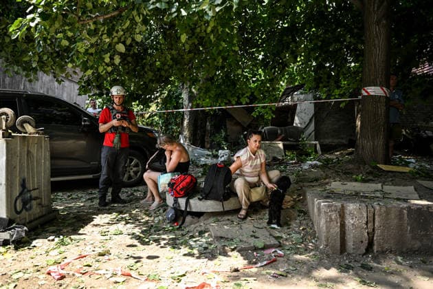 A volunteer from the Ukrainian Red Cross Society stands by residents affected by a Russian air strike, Zaporizhzhia, Ukraine, July 21, 2026. The Russian army attacked residential quarters of the south-eastern Ukrainian city with guided aerial bombs. At least two people were killed and nine injured. Cars, the apartment block, and non-residential buildings were damaged. The strike sparked fires. (Photo by Dmytro Smolienko Ukrinform) Russians strike Zaporizhzhia with guided bombs againRussians strike Zaporizhzhia with guided bombs again  Copyright: xDmytroxSmolienkox