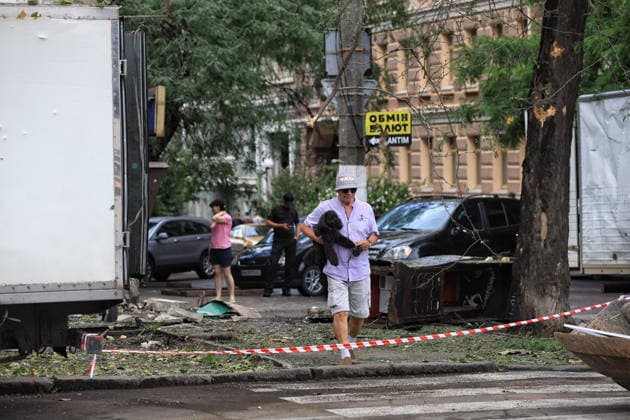 A man carrying a dog approaches a zebra crossing near a four-storey apartment block damaged by a Russian combined strike, Odesa, Ukraine, July 21, 2026. The Russian army carried out a missile and drone attack on the southern Ukrainian port city and the region. The attack damaged the residential building, nearby structures and cars. Three people were injured. (Photo by Nina Liashonok Ukrinform) Russians attack historical centre in Odesa  Copyright: xNinaxLiashonokx