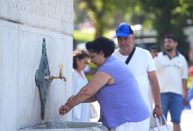Hot weather in Istanbul ISTANBUL, TURKIYE - JULY 22: A woman is washing her hands at the fountain as local and foreign tourists try to protect themselves from the hot weather by using umbrellas, face masks, hats, and hand fans in Istanbul, Turkiye, on July 22, 2026. Esra Bilgin Anadolu Istanbul Turkey. Editorial use only. Please get in touch for any other usage.  Copyright: x2026xAnadoluxEsraxBilginx