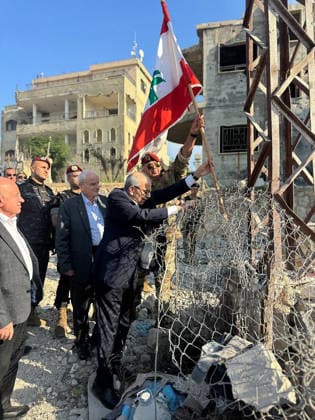 Lebanese Prime Minister Nawaf Salam places a national flag along a damaged street in the southern village of Zawtar al‘Gharbiya on Wednesday, July 22, 2026, following the withdrawal of Israeli troops from the area. During his visit, Salam said Beirut is working toward a complete Israeli withdrawal from occupied territories. The Lebanese army has recently deployed in the village as part of efforts to reassert state authority.  LEB2026072203 LebanesexPrimexMinister sxMedia