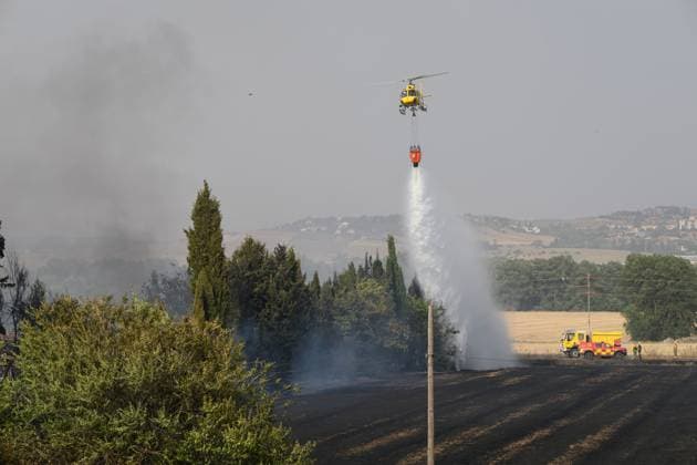 July 22, 2026, Madrid, Spain: MADRID, SPAIN Ã¢â‚¬ JULY 22, 2026: Firefighters work to extinguish a wildfire burning alongside the A-1 motorway near Madrid. Several fire engines and two firefighting helicopters are deployed to contain the blaze and prevent it from spreading. Madrid Spain  - ZUMAq101 20260722_zna_q101_242 Copyright: xTomasxCallex