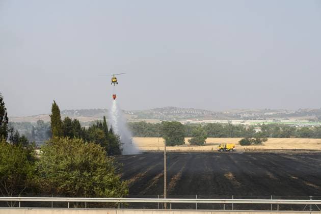 July 22, 2026, Madrid, Spain: MADRID, SPAIN Ã¢â‚¬ JULY 22, 2026: Firefighters work to extinguish a wildfire burning alongside the A-1 motorway near Madrid. Several fire engines and two firefighting helicopters are deployed to contain the blaze and prevent it from spreading. Madrid Spain  - ZUMAq101 20260722_zna_q101_243 Copyright: xTomasxCallex