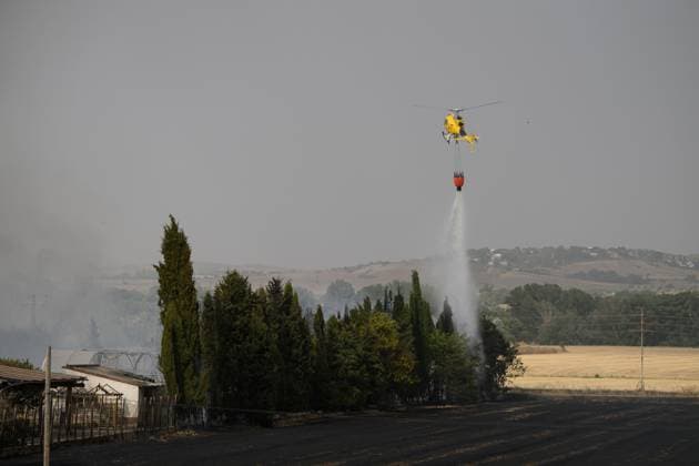 July 22, 2026, Madrid, Spain: MADRID, SPAIN Ã¢â‚¬ JULY 22, 2026: Firefighters work to extinguish a wildfire burning alongside the A-1 motorway near Madrid. Several fire engines and two firefighting helicopters are deployed to contain the blaze and prevent it from spreading. Madrid Spain  - ZUMAq101 20260722_zna_q101_247 Copyright: xTomasxCallex