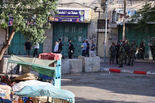 Hebron Market Closed for Tomb Visit Israeli soldiers and civilians stand near concrete barriers and shuttered shops in Hebron, Palestine, on July 23, 2026. Israeli forces closed the central market and restricted the movement of Palestinians in the city of Hebron during a raid on the area to secure settlers access to an ancient tomb, where they performed Jewish prayers. Hebron West Bank Palestinian Territories Copyright: xMosabxShawerx