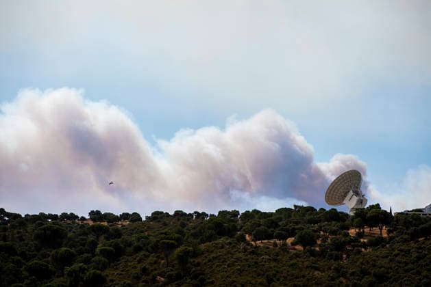 The fires in the Community of Madrid have merged into a single front, and a third front is being monitored from Ávila. Smoke from a nearby fire drifts over a NASA antenna on July 24, 2026, in Robledo de Chavela, Madrid, Spain. The fires affecting the Community of Madrid continue to spread unchecked and have merged into a single fire, while in Ávila, the Burgohondo fire is also advancing unchecked, forcing the central government to declare a national emergency on a day when weather forecasts of strong gusts of wind are hampering firefighting efforts. So far, 9,000 hectares have been burned in Ávila and another 6,000 in Madrid. JULY 24, 2026 FIRE UME SMOKE FOREST FIRES FIREFIGHTERS CIVIL GUARD EVACUATION NASA ANTENNA SPACE STATION DEEP SPACE  Copyright: xGabrixSolerax 7685551