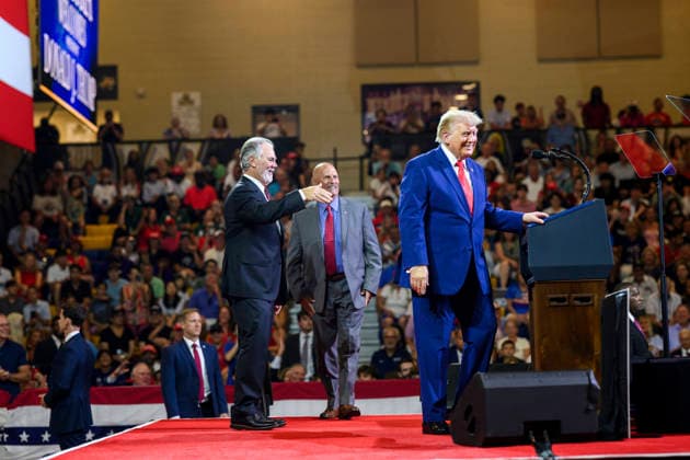 July 24, 2026, Marietta, Ga, United States: Cheered on by Atlanta Braves executive Mike Plant, left, and Brian Snitker, retired manager of the Atlanta Braves, center, U.S. President Donald Trump, takes the podium to deliver remarks on Trump Accounts and the economy at Wheeler High School, July 22, 2026, in Marietta, Georgia. Marietta United States - ZUMAp138 20260724_zaa_p138_016 Copyright: xMollyxRiley WhitexHousex