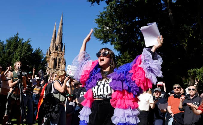 SING-IN PROTEST, Victoria Falconer theatre maker, music director and cabaret artist leads protestors inn song during a Sing-In™ protest in solidarity with Divine Playhouse at Hyde Park in Sydney, Saturday, July 25, 2026. The Trans Theatre Group was evicted from its rental property in Kent Street after its landlord Revelop terminated the venue s lease claiming offensive trade - a legal term deriving from an 1842 NSW law implemented to regulate foul smells and industrial waste - and never once in 184 years has a court been asked to consider if it extends to moral offensiveness. ( NO ARCHIVING SYDNEY NEW SOUTH WALES AUSTRALIA  Copyright: xJESSICAxHROMASx 20260725156860184116