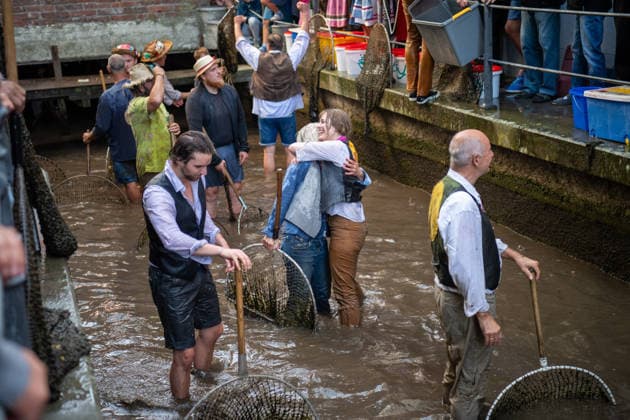 Ein Blick auf das traditionelle Bachausfischen während des Fischertags in Memmingen. Zahlreiche Fischer in teils historischer Kleidung waten durch den Stadtbach, um Fische zu fangen. Dicht gedrängt stehen Zuschauer am Ufer und verfolgen das Spektakel, das jährlich tausende Besucher anzieht. Der Memminger Fischertag ist eines der ältesten und bekanntesten Volksfeste in Bayern. Memmingen Bayern Deutschland *** A look at the traditional stream fishing during Memmingen’s Fishermen’s Day. Numerous fishermen, some in historical attire, wade through the town stream, to catch fish. Spectators stand packed tightly along the bank, watching the spectacle, which attracts thousands of visitors every year. Memmingen Fishermen’s Day is one of the o