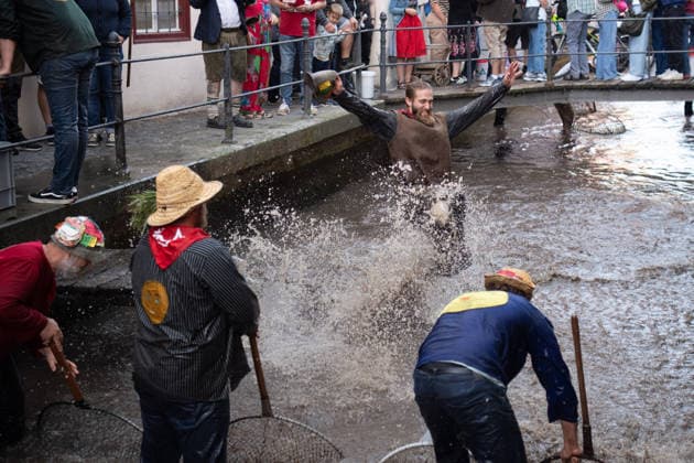 Ein Blick auf das traditionelle Bachausfischen während des Fischertags in Memmingen. Zahlreiche Fischer in teils historischer Kleidung waten durch den Stadtbach, um Fische zu fangen. Dicht gedrängt stehen Zuschauer am Ufer und verfolgen das Spektakel, das jährlich tausende Besucher anzieht. Der Memminger Fischertag ist eines der ältesten und bekanntesten Volksfeste in Bayern. Memmingen Bayern Deutschland *** A look at the traditional stream fishing during Memmingen’s Fishermen’s Day. Numerous fishermen, some in historical attire, wade through the town stream, to catch fish. Spectators stand packed tightly along the bank, watching the spectacle, which attracts thousands of visitors every year. Memmingen Fishermen’s Day is one of the o