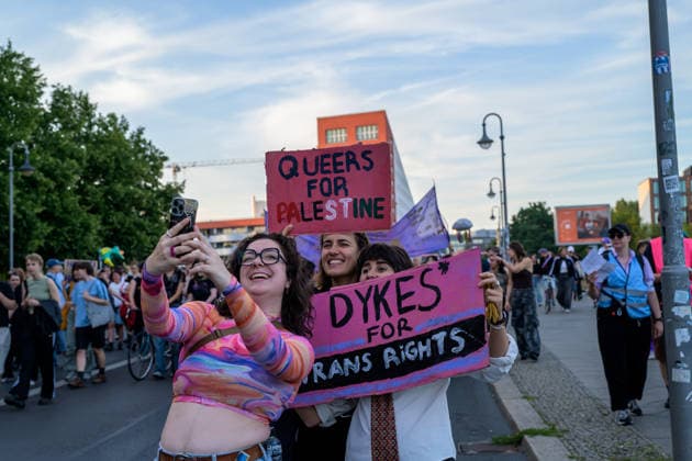 July 24, 2026, Berlin, Berlin, Germany: Demonstrators take selfie photos with their phone and showing their placards in support of Palestine and Trans people, at Dyke* March 2026, on July 24 2026, in Berlin, Germany. Thousands of demonstrators marched in the streets of Berlin s City Center and Kreuzberg districts for the annual Dyke* March just a day before the annual CSD parade and Internationalist Queer Pride Berlin Germany  - ZUMAk201 20260724_zip_k201_015 Copyright: xNikosxKanistrasx