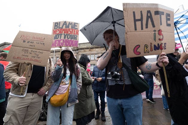 July 25, 2026, Glasgow, Scotland, UK: Pro-immigration protesters aligned with Stand Up To Racism Scotland and other allied organisations hold placards and banners during a demonstration in Glasgow. The protest took place amid heightened tensions over immigration and asylum seekers following months of unrest and protests across Scotland and was met with a counter protest held by anti-immigration supporters. Glasgow UK  - ZUMAs357 20260725_zip_s357_004 Copyright: xCameronxScottx