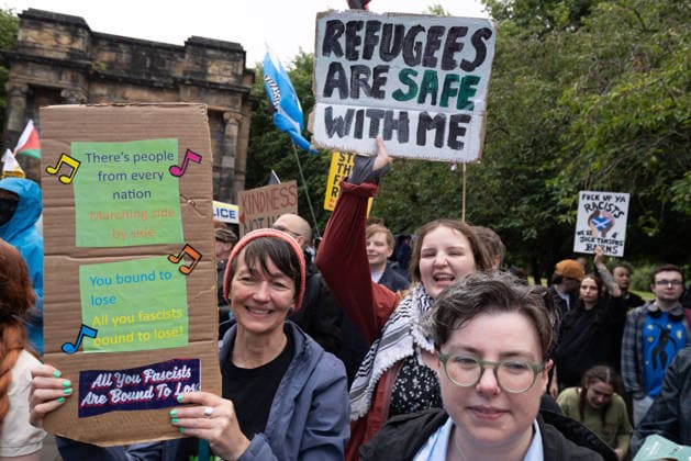 July 25, 2026, Glasgow, Scotland, UK: Pro-immigration protesters aligned with Stand Up To Racism Scotland and other allied organisations hold placards and banners during a demonstration in Glasgow. The protest took place amid heightened tensions over immigration and asylum seekers following months of unrest and protests across Scotland and was met with a counter protest held by anti-immigration supporters. Glasgow UK - ZUMAs357 20260725_zip_s357_005 Copyright: xCameronxScottx