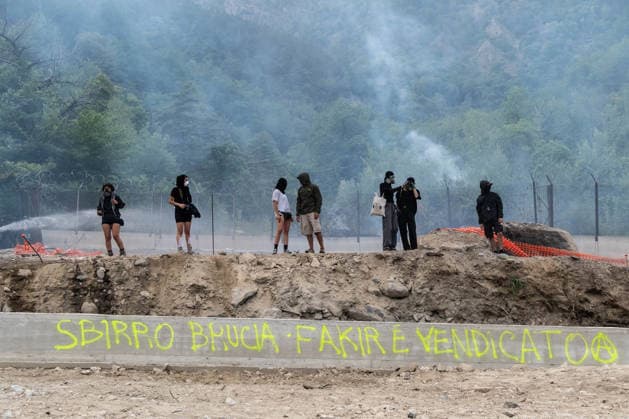 July 25, 2026, Susa, Piedmont, Italy: On July 25, 2026, thousands of people departed from AltaFelicito , a music festival in Venaus, to reach the construction sites of the TAV (High speed rail), a railway project to connect Italy and France. The demonstrators managed to enter the site and there clashed with the police, who responded with tear gas. Many of the buildings inside were put on fire, including two police vehicles. The TAV project has been highly contested during the last 30 years because of environmental damages and increasing costs. Susa Italy  - ZUMAs377 20260725_znp_s377_004 Copyright: xPietroxStariccox