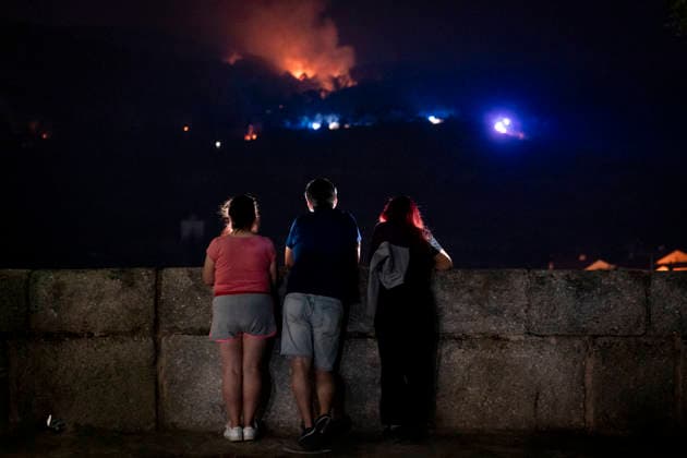 The fire is spreading slowly at night and has lost some intensity, but winds are expected to pick up this morning. Several people are watching the fire on July 25, 2026, in San Martín de Valdeiglesias, Madrid, Spain. Overnight, the change in weather conditions—with less wind, higher humidity, and cooler temperatures—has helped, although the fire remains active. The authorities’ priority is to prevent the fire from reaching El Escorial or merging with the one affecting the Burgohondo area, in Ávila. July 25, 2026. On foot in San Martín de Valdeiglesias, Madrid, San Martín de Valdeiglesias, Madrid, Spain  Copyright: xA.xPÃ rezxMecax 7688148