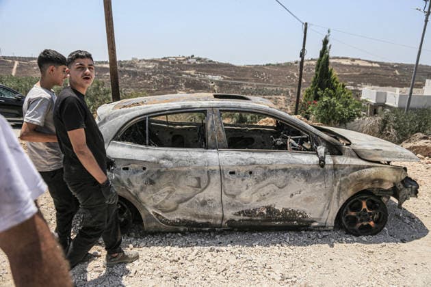 July 25, 2026, Nablus, West Bank, Palestine: Palestinians inspect a burned-out vehicle set ablaze by a group of Jewish settlers in the village of Tell, southwest of Nablus in the West Bank. This attack came in retaliation for the killing of two settlers and four Palestinians in Tell, southwest of Nablus in the West Bank. In response, settlers set fire to Palestinian cars and homes in Tell and the neighboring village of Qalqilya Sara. Meanwhile, the Israeli army announced its readiness for a military operation in the northern West Bank, which is under the control of the Palestinian Authority. Nablus Palestine - ZUMAs197 20260725_aaa_s197_229 Copyright: xNasserxishatyehx