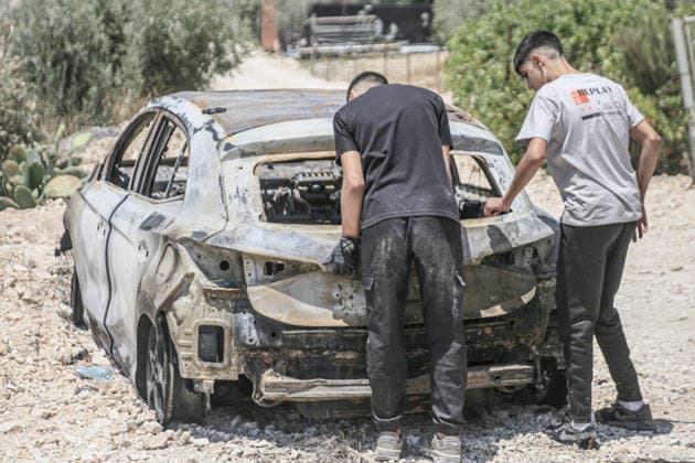 July 25, 2026, Nablus, West Bank, Palestine: Palestinians inspect a burned-out vehicle set ablaze by a group of Jewish settlers in the village of Tell, southwest of Nablus in the West Bank. This attack came in retaliation for the killing of two settlers and four Palestinians in Tell, southwest of Nablus in the West Bank. In response, settlers set fire to Palestinian cars and homes in Tell and the neighboring village of Qalqilya Sara. Meanwhile, the Israeli army announced its readiness for a military operation in the northern West Bank, which is under the control of the Palestinian Authority. Nablus Palestine - ZUMAs197 20260725_aaa_s197_236 Copyright: xNasserxishatyehx
