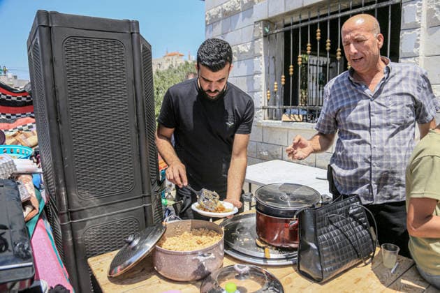 July 25, 2026, Nablus, West Bank, Palestine: A Palestinian family prepares food outside their burned home, which was set on fire by Jewish settlers in the village of Tell, southwest of Nablus in the West Bank. This attack came in retaliation for the killing of two settlers and four Palestinians in Tell, southwest of Nablus in the West Bank. In response, settlers set fire to Palestinian cars and homes in Tell and the neighboring village of Qalqilya Sara. Meanwhile, the Israeli army announced its readiness for a military operation in the northern West Bank, which is under the control of the Palestinian Authority. Nablus Palestine - ZUMAs197 20260725_aaa_s197_250 Copyright: xNasserxishatyehx