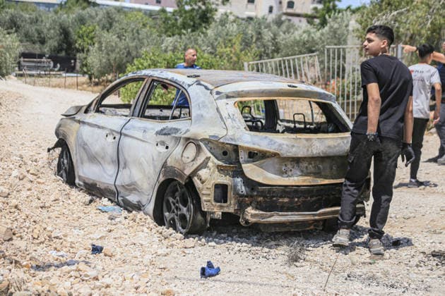 July 25, 2026, Nablus, West Bank, Palestine: Palestinians inspect a burned-out vehicle set ablaze by a group of Jewish settlers in the village of Tell, southwest of Nablus in the West Bank. This attack came in retaliation for the killing of two settlers and four Palestinians in Tell, southwest of Nablus in the West Bank. In response, settlers set fire to Palestinian cars and homes in Tell and the neighboring village of Qalqilya Sara. Meanwhile, the Israeli army announced its readiness for a military operation in the northern West Bank, which is under the control of the Palestinian Authority. Nablus Palestine - ZUMAs197 20260725_aaa_s197_253 Copyright: xNasserxishatyehx
