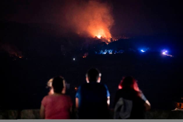 The fire is spreading slowly at night and has lost some intensity, but winds are expected to pick up this morning. Several people are watching the fire on July 25, 2026, in San Martín de Valdeiglesias, Madrid, Spain. Overnight, the change in weather conditions—with less wind, higher humidity, and cooler temperatures—has helped, although the fire remains active. The authorities’ priority is to prevent the fire from reaching El Escorial or merging with the one affecting the Burgohondo area, in Ávila. July 25, 2026. On foot in San Martín de Valdeiglesias, Madrid, San Martín de Valdeiglesias, Madrid, Spain  Copyright: xA.xPÃ rezxMecax 7688180