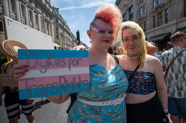 July 25, 2026, London, Westminster, United Kingdom: Two activists hold a placard during the Trans+ Pride London march. Thousands of people joined the seventh annual Trans+ Pride march and rally in central London. The event celebrated the trans community while promoting equality and challenging discrimination through visibility and collective action. The march set off from Langham Place at 2 p.m., paused at three points for speeches and to welcome additional participants, and concluded with a rally and further speeches in Trafalgar Square. London United Kingdom - ZUMAs197 20260725_aaa_s197_277 Copyright: xJamesxWilloughbyx