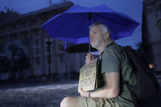Ukrainians Protest - Kharkiv A man holding a handwritten sign reading ...not fatigues, oh veut Fedorov! stands in a central square holding a blue umbrella during an evening protest against Ukrainian President Volodymyr Zelenskiy s decision to replace Fedorov as Defence Minister, in Kharkiv, Ukraine, on July 25, 2026. The demonstrator, wearing an olive-green shirt and backpack, expresses public dissatisfaction with the ministerial change during the twilight hour. Photo by Yevhen Titov ABACAPRESS.COM Kharkiv Kharkiv Oblast Ukraine  Copyright: xTitovxYevhen ABACAx