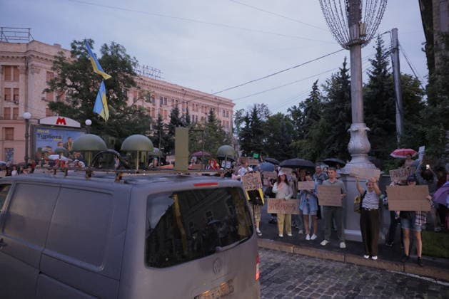 Ukrainians Protest - Kharkiv Protesters holding signs and umbrellas gather in central Kharkiv, Ukraine, demonstrating against President Zelenskiy s decision to replace Fedorov as Defence Minister, on July 25, 2026. The demonstration took place in a main square near the metro station and administrative buildings, with participants expressing discontent over the ministerial change. Several dozen people participated in the evening protest. Photo by Yevhen Titov ABACAPRESS.COM Kharkiv Kharkiv Oblast Ukraine  Copyright: xTitovxYevhen ABACAx