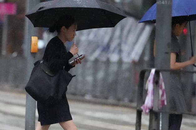 (260726) -- HONG KONG, July 26, 2026 -- People walk amid rain in Hong Kong, south China, July 26, 2026. The Hong Kong Observatory issued the No. 8 Northwest Gale or Storm Signal on Saturday night under the effect of super typhoon Noul. The No. 8 signal is the third-highest warning under Hong Kong s weather system, which has five rankings for typhoons. (Photo by Xinhua) CHINA-HONG KONG-NO. 8 TYPHOON SIGNAL (CN) LuixSiuxWai 