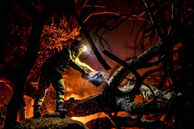 Evacuation underway as wildfires threaten towns in Spain LA ADRADA, AVILA, SPAIN – JULY 26: A firefighter uses a chainsaw to cut through burning trees during overnight wildfire suppression operations in La Adrada, in Spain s Avila province, on July 26, 2026. Fire crews worked throughout the night to contain the fast-moving blaze and prevent it from spreading toward nearby residential areas. Diego Radames Anadolu Avila Spain. Editorial use only. Please get in touch for any other usage.  Copyright: x2026xAnadoluxDiegoxRadamesx