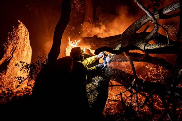Evacuation underway as wildfires threaten towns in Spain LA ADRADA, AVILA, SPAIN – JULY 26: A firefighter uses a chainsaw to cut through burning trees during overnight wildfire suppression operations in La Adrada, in Spain s Avila province, on July 26, 2026. Fire crews worked throughout the night to contain the fast-moving blaze and prevent it from spreading toward nearby residential areas. Diego Radames Anadolu Avila Spain. Editorial use only. Please get in touch for any other usage.  Copyright: x2026xAnadoluxDiegoxRadamesx
