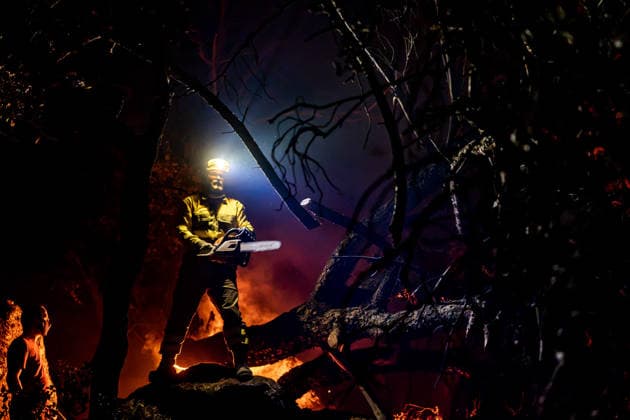 Evacuation underway as wildfires threaten towns in Spain LA ADRADA, AVILA, SPAIN – JULY 26: A firefighter uses a chainsaw to cut through burning trees during overnight wildfire suppression operations in La Adrada, in Spain s Avila province, on July 26, 2026. Fire crews worked throughout the night to contain the fast-moving blaze and prevent it from spreading toward nearby residential areas. Diego Radames Anadolu Avila Spain. Editorial use only. Please get in touch for any other usage.  Copyright: x2026xAnadoluxDiegoxRadamesx
