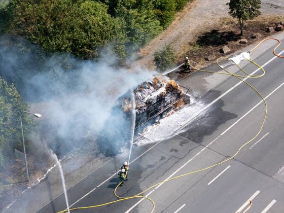 Strohballen fangen auf Anhänger Feuer Landwirt koppelt Traktor ab Flammen greifen auf Vegetation über Am 26.07.2026 geriet auf der L3114 zwischen Groß-Zimmern und Dieburg ein mit Strohquaderballen beladener Anhänger eines Traktors in Brand. Ein Landwirt koppelte nach Hinweisen von Autofahrern den Traktor ab und alarmierte die Feuerwehr, während der Brand auf die gesamte Ladung übergriff. Durch starken Wind breitete sich das Feuer zusätzlich auf einen Grünstreifen und angrenzende Vegetation aus, die Polizei sperrte die Landstraße. Die Feuerwehr Dieburg löschte den Brand mit Unterstützung der Feuerwehr Groß-Zimmern, laut Landwirt liegt eine natürliche Selbstentzündung nahe. Menschen wurden nicht verletzt. Dieburg L3114 H