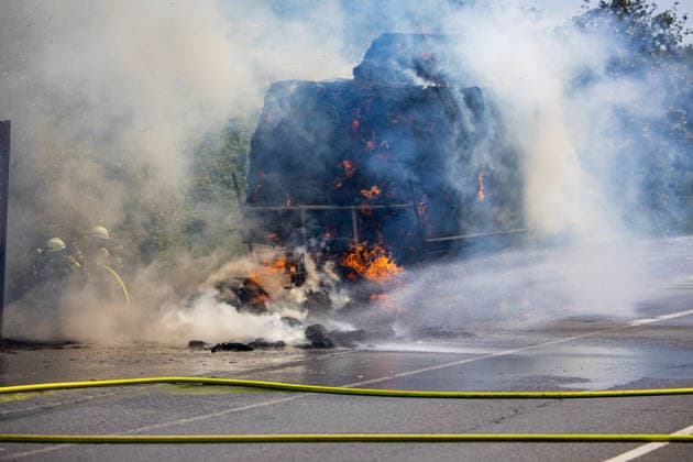 Strohballen fangen auf Anhänger Feuer Landwirt koppelt Traktor ab Flammen greifen auf Vegetation über Am 26.07.2026 geriet auf der L3114 zwischen Groß-Zimmern und Dieburg ein mit Strohquaderballen beladener Anhänger eines Traktors in Brand. Ein Landwirt koppelte nach Hinweisen von Autofahrern den Traktor ab und alarmierte die Feuerwehr, während der Brand auf die gesamte Ladung übergriff. Durch starken Wind breitete sich das Feuer zusätzlich auf einen Grünstreifen und angrenzende Vegetation aus, die Polizei sperrte die Landstraße. Die Feuerwehr Dieburg löschte den Brand mit Unterstützung der Feuerwehr Groß-Zimmern, laut Landwirt liegt eine natürliche Selbstentzündung nahe. Menschen wurden nicht verletzt. Dieburg L3114 H