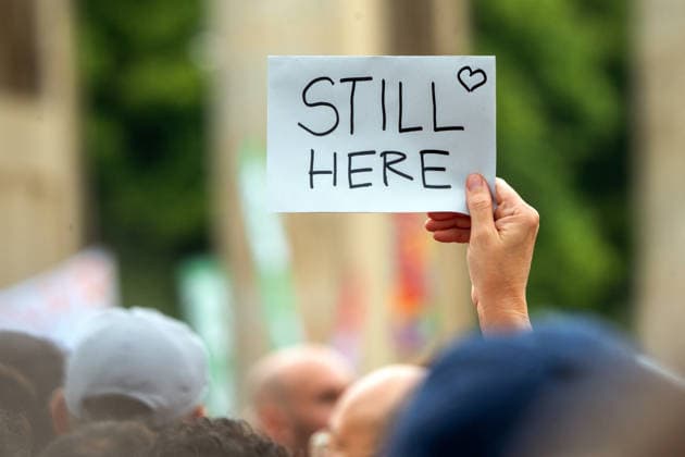Trauer- und Gedenkveranstaltung für die Opfer des CSD-Anschlags, Schild: Still here, Brandenburger Tor, Berlin, 26. Juli 2026 Deutschland, Berlin, 26. Juli 2026, Trauer- und Gedenkveranstaltung für die Opfer des CSD-Anschlags, Schild: Still here,, Brandenburger Tor,, 17 Stunden nach dem Terroranschlag im Tiergarten, bei dem ein Mensch starb und weitere teils schwer verletzt wurden, 5.000 Leute versammeln sich am Pariser Platz, aufgerfen hatte der Berliner FLINTA-Chor D-Dur Dykes, Sonntag ab 14 Uhr, *** Mourning and memorial service for the victims of the CSD attack, Still Here sign, Brandenburg Gate, Berlin, July 26, 2026 Germany, Berlin, July 26, 2026, Mourning and memorial service for the victims of the CSD attack, Still Here sign,