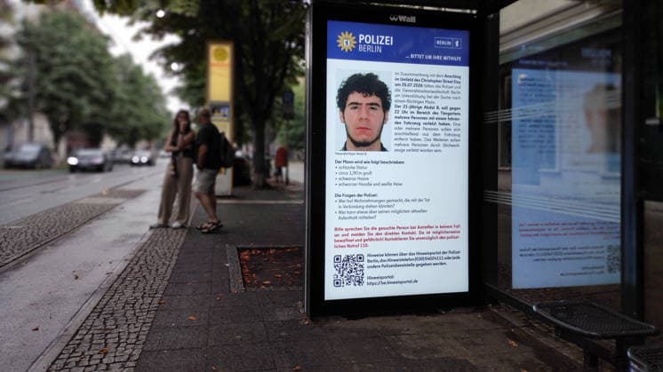 26.07.2026, Berlin - Deutschland. Öffentliche Fahndung nach Abdul B nach dem Terroranschlag im Tiergarten in Zusammenhang mit dem Christopher Street Day an einer Straßenbahnhaltestelle. *** July 26, 2026, Berlin, Germany: Public manhunt for Abdul B following the terrorist attack in Tiergarten in connection with Christopher Street Day at a streetcar stop