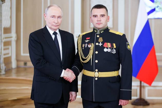 RUSSIA, ST PETERSBURG - JULY 26, 2026: Russia s President Vladimir Putin (L) awards Jr Sgt Yuri Malofeyev Russia s Order of St George - St George s Cross (6th class) during a ceremony to present state awards at the Admiralty Building on Russian Navy Day. Peter Kovalev TASS  95494191