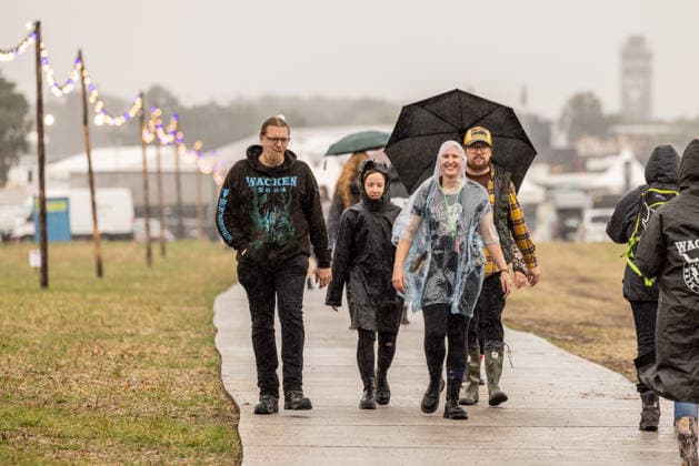 Anreise Wacken Open Air 2026 trotz Regenschauern gut organisiert, Veranstalterkonzept geht auf. Trotz des am Sonntag pünktlich einsetzenden Regens lassen sich die früh anreisenden Fans nicht abhalten und machen das Beste aus der Situation. Feste Wege und ein besseres Konzept zeigen bereits Wirkung. Wacken Wacken open Air Schleswig Holstein Deutschland _5DL7147 *** Travel to Wacken Open Air 2026 Well Organized Despite Rain Showers, Organizers’ plan pays off. Despite the rain starting right on time on Sunday, fans who arrived early weren’t deterred and made the best of the situation. Paved paths and an improved plan are already showing results. Wacken, Wacken Open Air, Schleswig-Holstein, Germany, 5DL7147