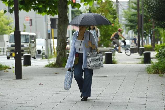 Sudden summer thunderstorm interrupts relief from Tokyo heat TOKYO, JAPAN - JULY 26 : A pedestrian walks with an umbrella along a sidewalk in Tokyo, Japan, on July 26, 2026, under unstable summer weather following a period of intense heat. David Mareuil Anadolu Tokyo Japan. Editorial use only. Please get in touch for any other usage.  Copyright: x2026xAnadoluxDavidxMareuilx