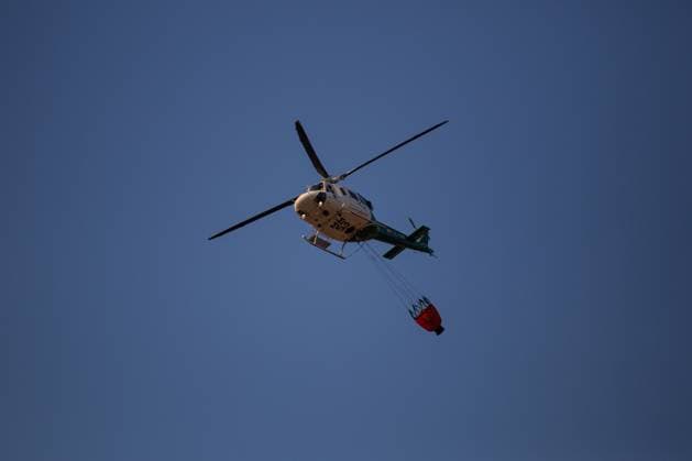 Firefighting helicopters battle reignited San Martin de Valdeiglesias wildfire near Navas del Rey NAVAS DEL REY (MADRID), SPAIN JULY 26, 2026: Firefighting helicopters carry out water-dropping operations as a large column of smoke rises from the reignited San Martin de Valdeiglesias wildfire, visible from several locations around Navas del Rey, near Madrid, on July 26. The series documents the aerial firefighting response, emergency vehicles and road closures implemented as crews continue efforts to contain the fire. Navas del Rey Spain Copyright: x xEugenioxRodriguezxRigox xJNAxPressx
