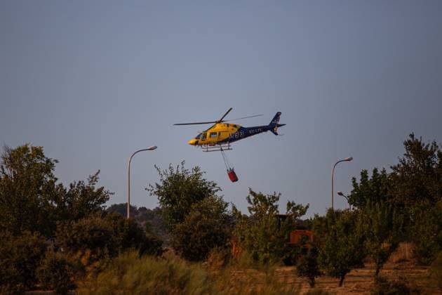 Firefighting helicopters battle reignited San Martin de Valdeiglesias wildfire near Navas del Rey NAVAS DEL REY (MADRID), SPAIN JULY 26, 2026: Firefighting helicopters carry out water-dropping operations as a large column of smoke rises from the reignited San Martin de Valdeiglesias wildfire, visible from several locations around Navas del Rey, near Madrid, on July 26. The series documents the aerial firefighting response, emergency vehicles and road closures implemented as crews continue efforts to contain the fire. Navas del Rey Spain Copyright: x xEugenioxRodriguezxRigox xJNAxPressx