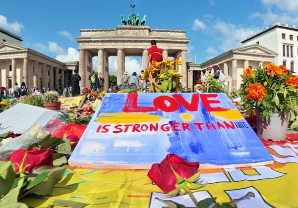 Zahlreiche Menschen haben vor dem Brandenburger Tor Blumen, Kerzen, Regenbogenfahnen niedergelegt und trauern um die Opfer des CSD-Anschlags, Berlin, 27. Juli 2026 Deutschland, Berlin, 27. Juli 2026, Gedenkort für die Opfer des CSD-Anschlags vor dem Brandenburger Tor, zahlreiche Menschen haben Blumen, Kerzen, Regenbogenfahnen niedergelegt, einen Erinnerungsort geschaffen, im Mittelpunkt liegt ein handgemaltes Schild mit der Aufschrift: Love is stronger than hate, das Blumenmeer setzt ein sichtbares Zeichen gegen Hass und Gewalt, Pariser Platz am Montagmorgen um 10 Uhr, 36 Stunden nach dem islamistischen Terroranschlag im Tiergarten, bei dem ein Mensch starb und weitere teils schwer verletzt wurden, *** Numerous people have laid flowers, ca