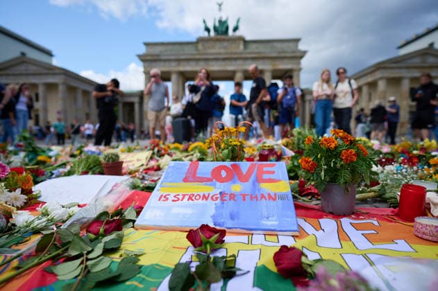 Blumen und Beileidsbekundungen vor dem Brandenburger Tor zwei Tage nach dem Anschlag auf die Feiern des 48. Berliner Christopher Street Day (CSD) mit einer Toten und 29 teils schwer Verletzten (Foto vom 27.07.2026). Der Christopher Street Day in Berlin war in der Nacht zum Sonntag von einem mutmasslich islamistisch motivierten Anschlag erschuettert worden, als ein Mann mit einem Kastenwagen in eine Menschenmenge im Berliner Tiergarten fuhr und mit einer Stichwaffe auf weitere Passanten losging. (Siehe epd-Bericht vom 27.07.2026) EDITORIAL USE ONLY *** Flowers and messages of condolence in front of the Brandenburg Gate two days after the attack on the celebrations for the 48th Berlin Christopher Street Day (CSD), which left one person dead a Copyright: epd-bild ChristianxDitsch D26D0727TrauerCSDAnschlag121250