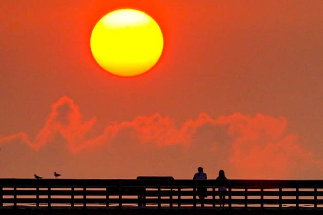 July 27, 2026, Isle of Palms, South Carolina, USA: People watch the sunrise over the Atlantic Ocean on a hot and muggy morning from Isle of Palms Pier on Front Beach, in Isle of Palms, South Carolina. Isle Of Palms USA  - ZUMAe02_ 20260727_zaf_e02_001 Copyright: xRichardxEllisx