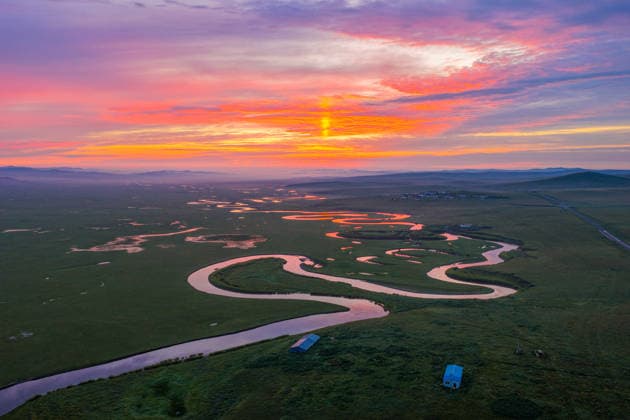 HULUNBUIR, CHINA - JULY 27: Morning mist floats over the Mergle River as dawn light illuminates the grassland on July 27, 2026 in Hulunbuir, Inner Mongolia Autonomous Region of China. The scenic view features the winding river reflecting the colorful sky amidst layers of distant mountains.  Copyright: xVCGx 111656629932